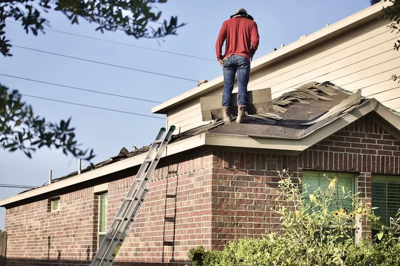 Professional roofer working on a residential roof in College Corner